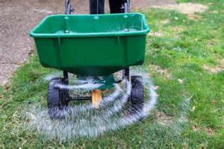 How do you set a spreader for overseeding?